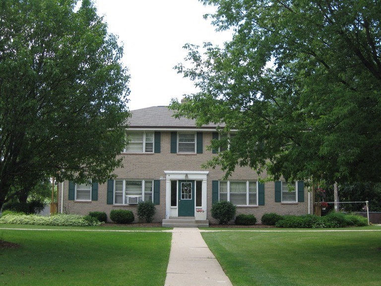 a brick house with a lawn in front of it