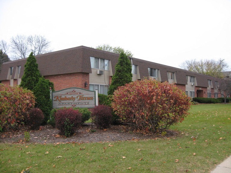 an apartment building with a sign in front