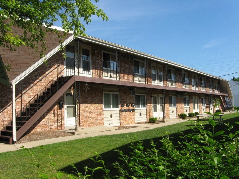 a brick apartment building with stairs and a balcony