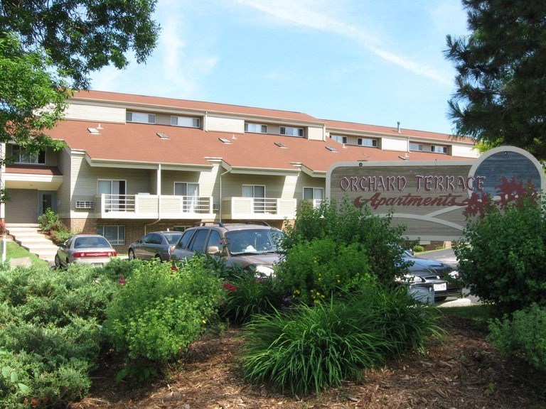 a building with a sign and cars parked in front of it