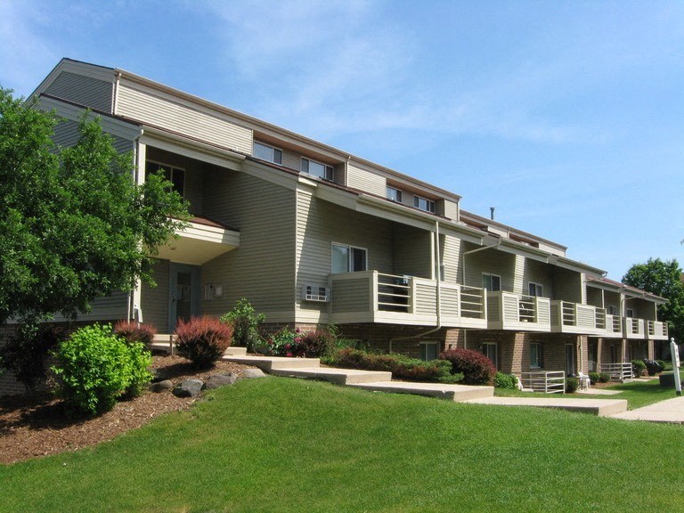 a large apartment building with balconies and a lawn
