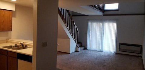 a kitchen with a sink and a staircase in a house