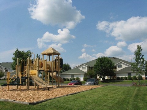 a playground in a yard in front of some houses