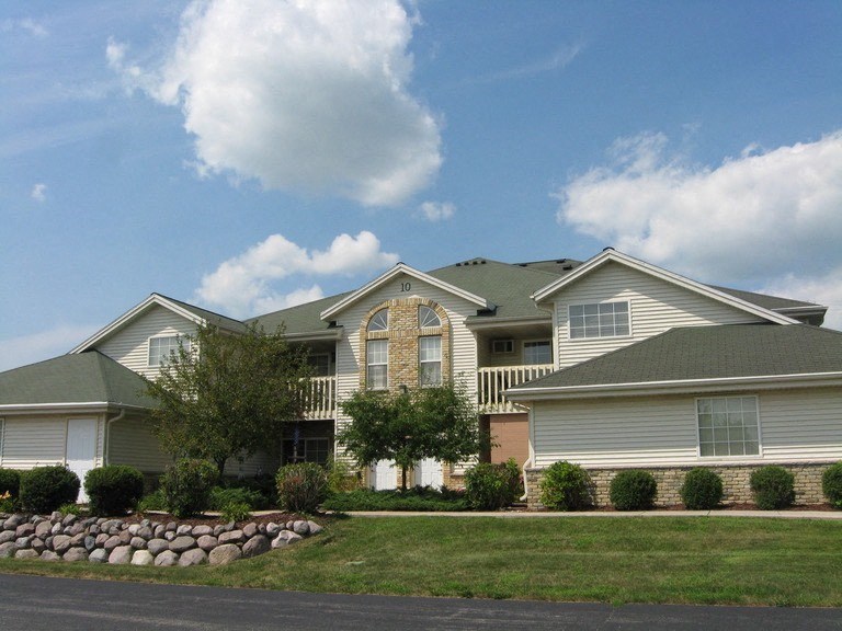 a house with a green lawn and a blue sky