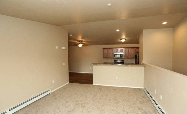 an empty room with a kitchen and a living room
