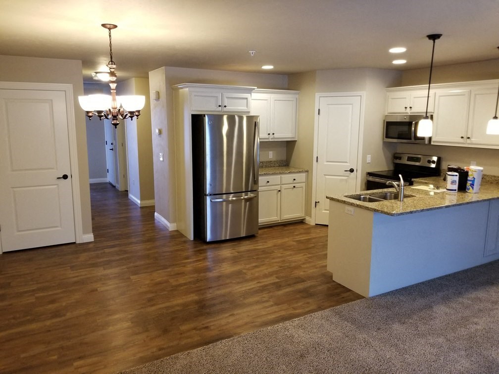 an empty kitchen with a stainless steel refrigerator
