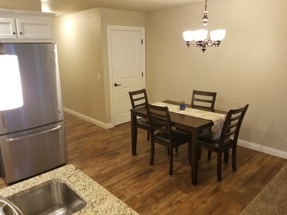 a kitchen and dining room with a table and chairs and a refrigerator