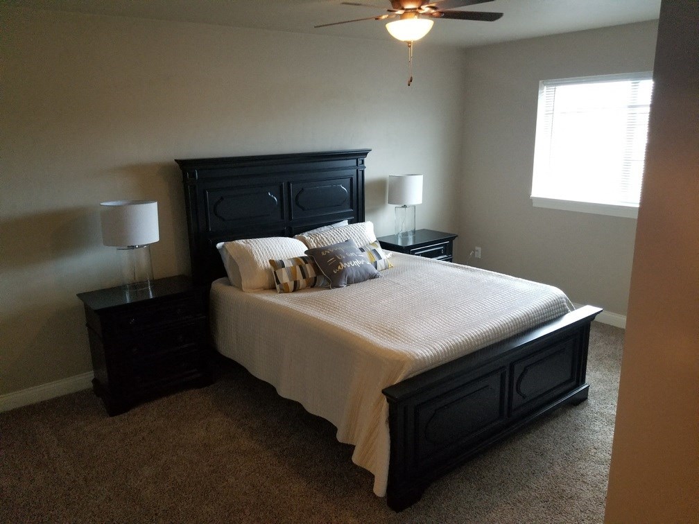 a bedroom with a bed and a ceiling fan
