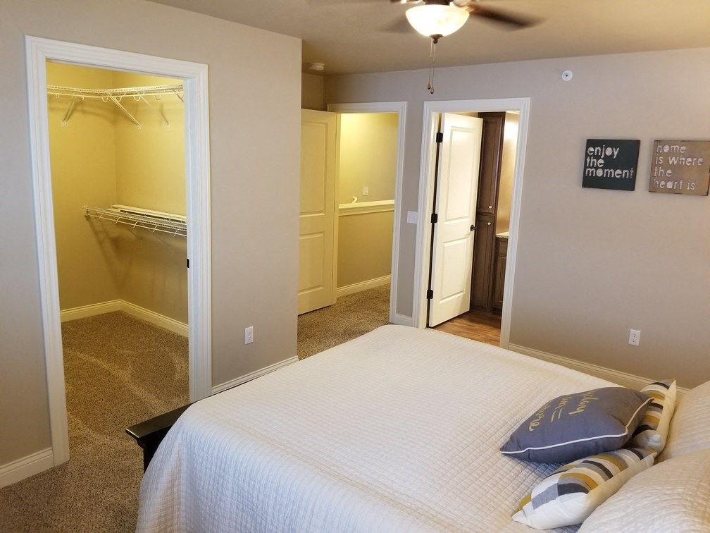 a bedroom with a bed and a closet and a ceiling fan