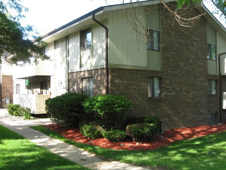 a brick house with a sidewalk in front of it