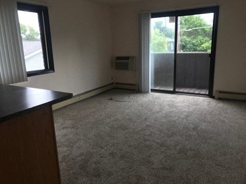 an empty living room with a door to a balcony