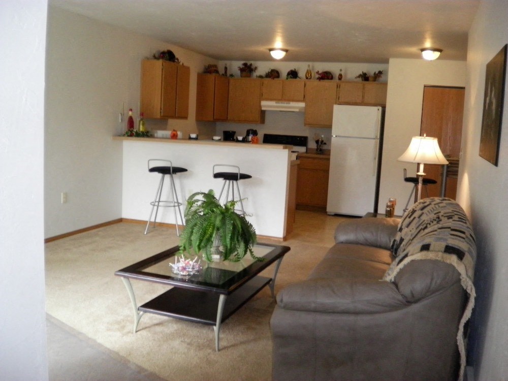 an open kitchen and living room with a couch and a table