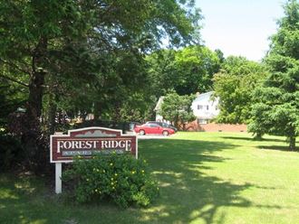 a sign for forest ridge in front of a field