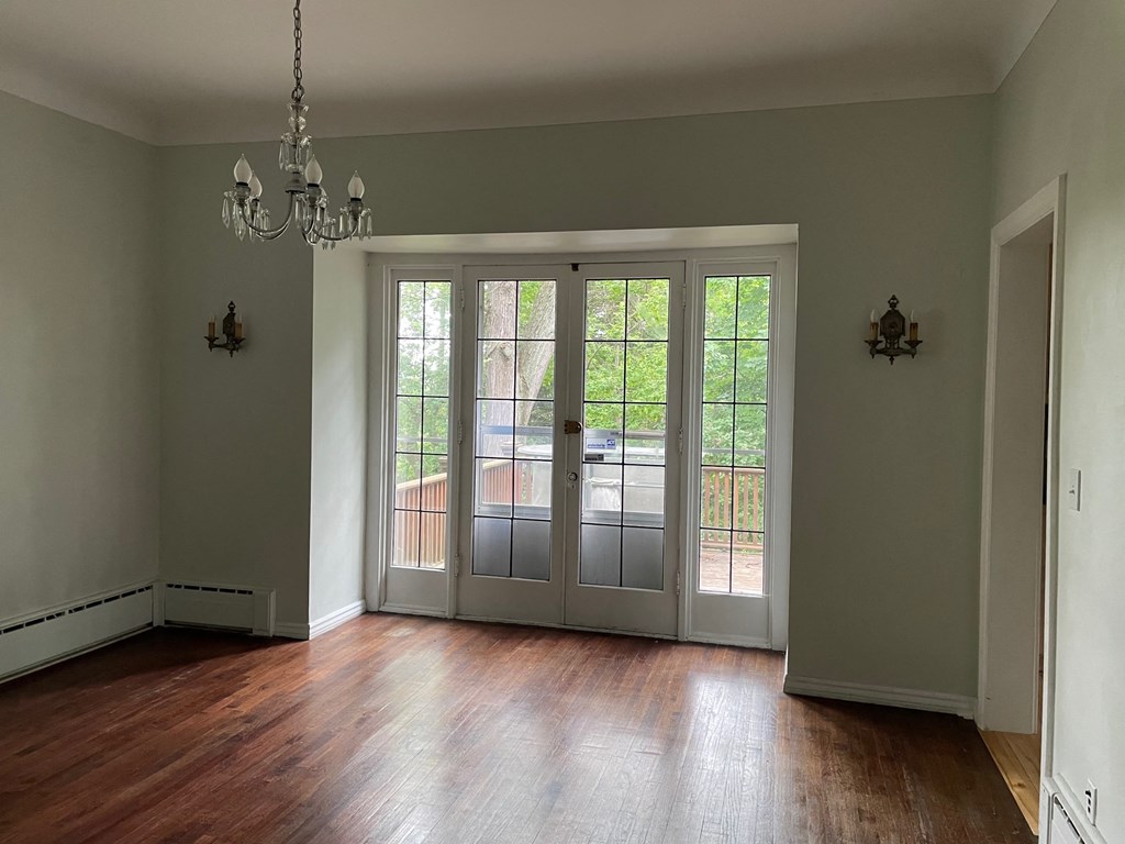 an empty living room with a wood floor and doors