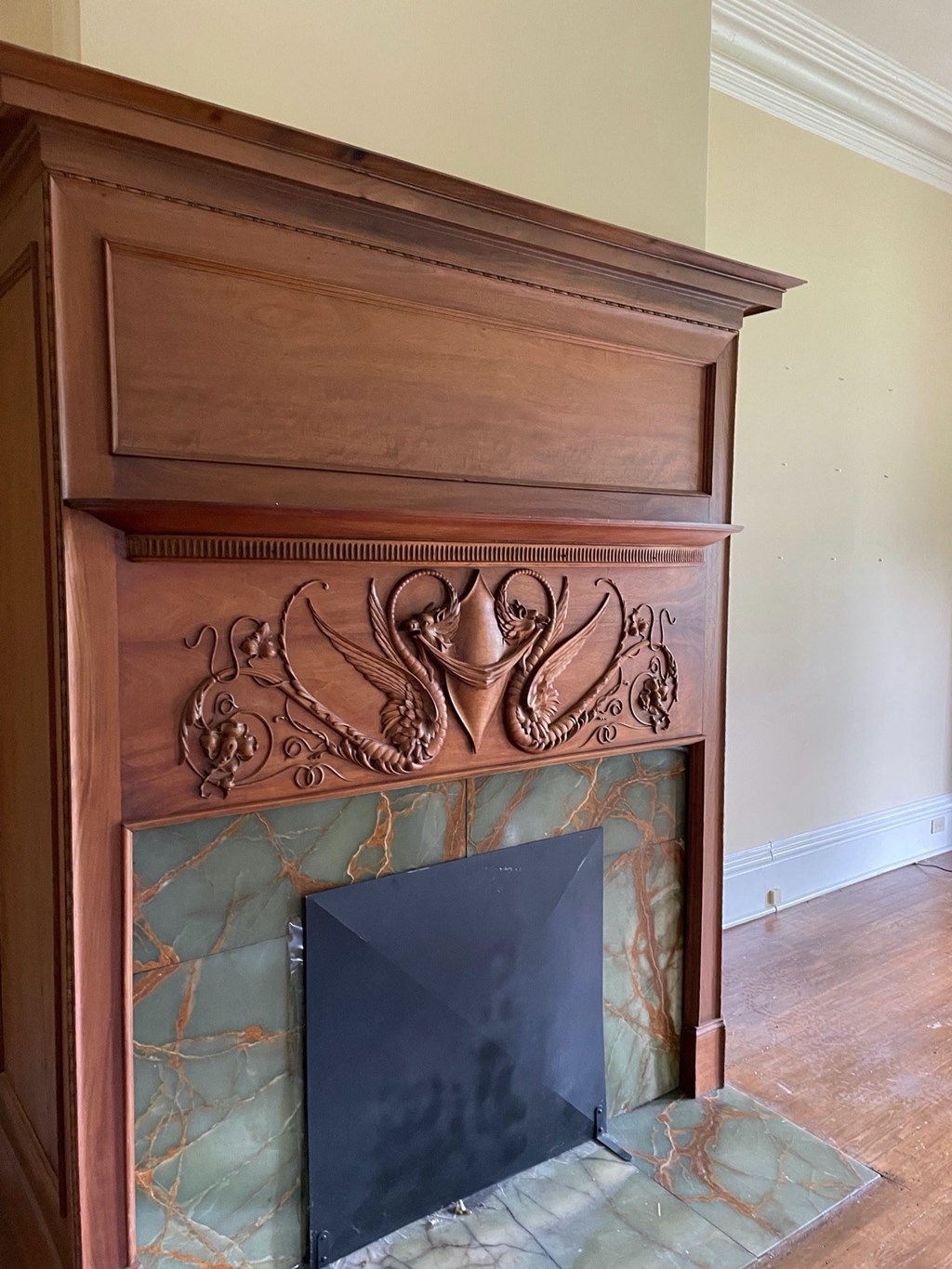 a fireplace with a wooden mantel and a mirror on it
