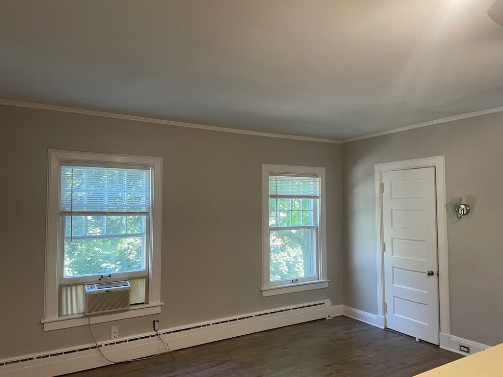 an empty room with two windows and a white door