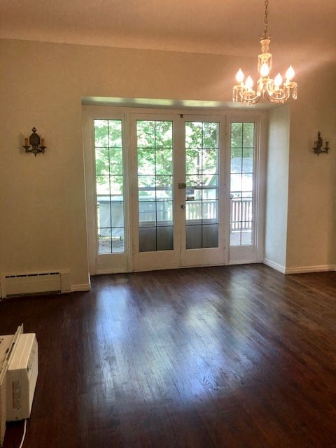 an empty living room with doors and a chandelier