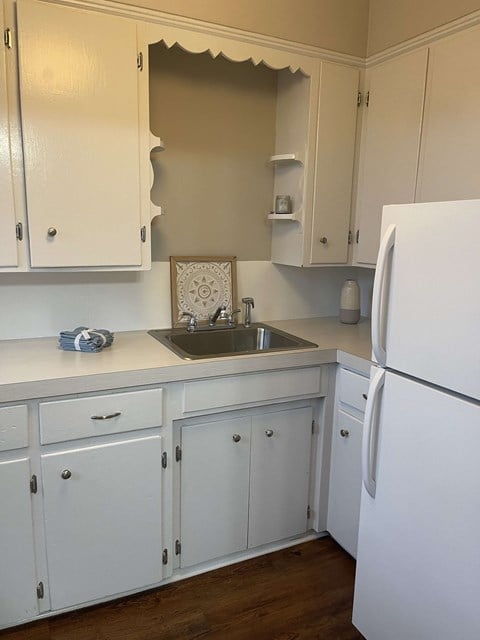 a kitchen with white cabinets and a sink and refrigerator