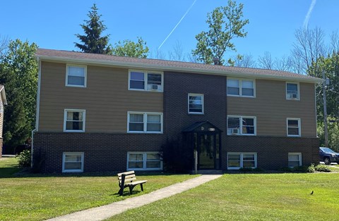 A building with a brown and beige exterior and a black door.