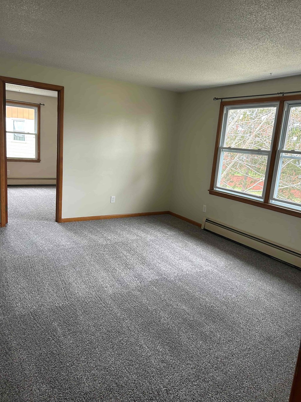 A room with a carpeted floor and a window.