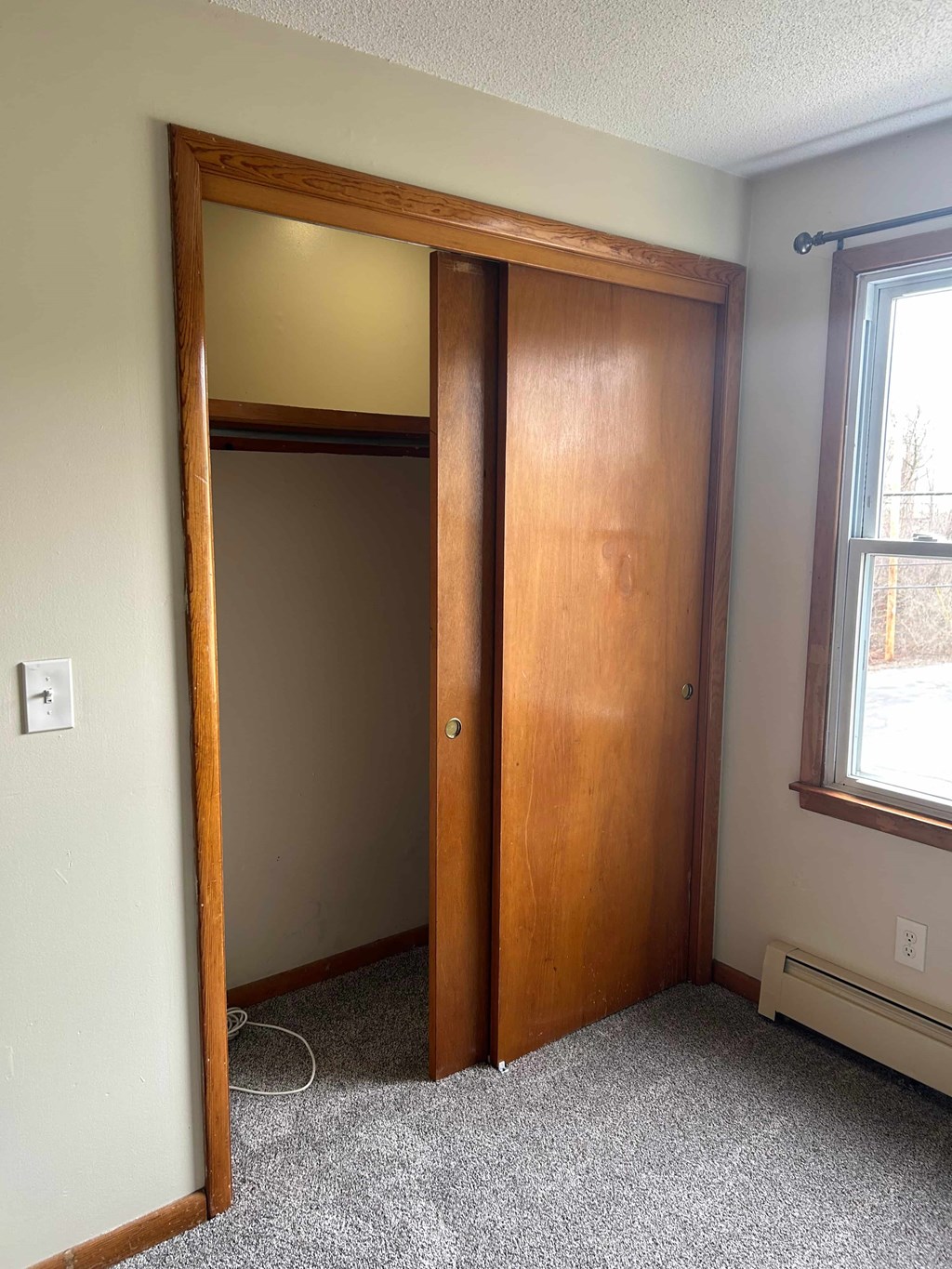 A room with a brown door and a window.