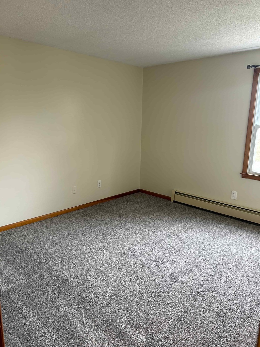 A room with a carpeted floor and a window.