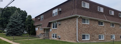 A brown brick building with a white pipe running down the side.
