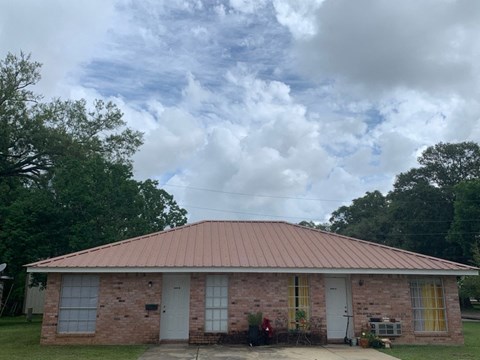 an old brick house with a cloudy sky in the background