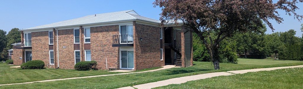 A brick building with a balcony on the second floor.