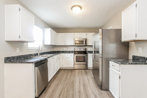 A kitchen with white cabinets and stainless steel appliances.