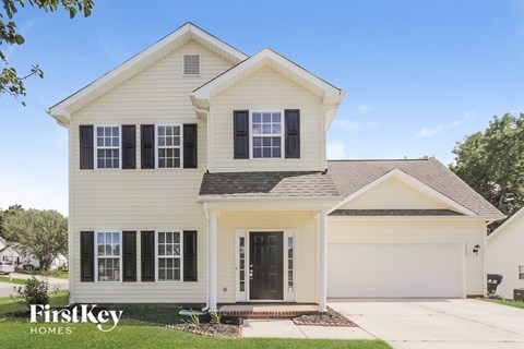 A two-story house with a white exterior and a black door.