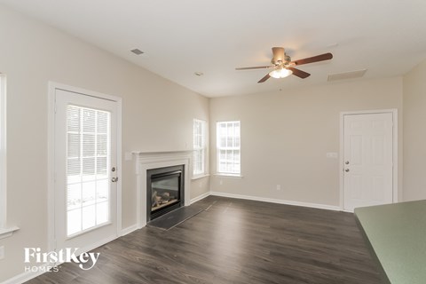 A spacious room with a fireplace and a ceiling fan.