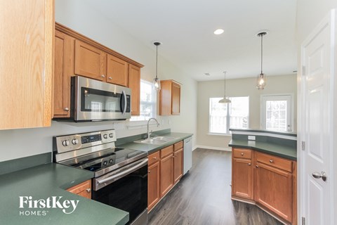 A kitchen with wooden cabinets and a stainless steel microwave.