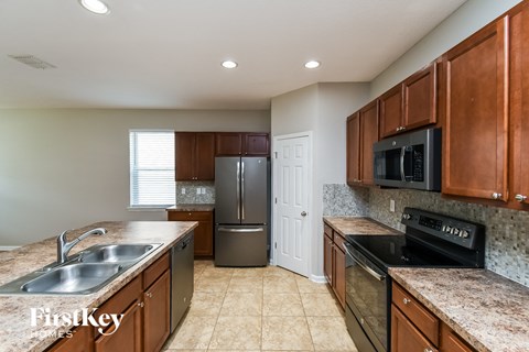 A kitchen with brown cabinets and a stainless steel refrigerator.