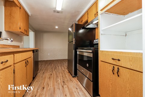 A kitchen with wooden cabinets and a black oven.