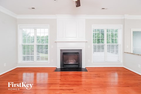 A living room with a fireplace and wood floors.