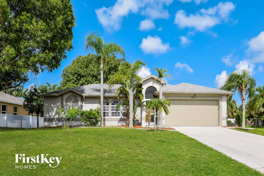 A house with a white garage door and palm trees in front.