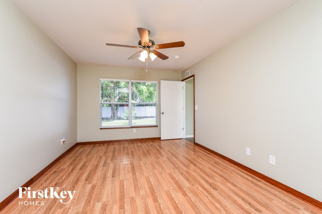 A room with wooden floors and a ceiling fan.
