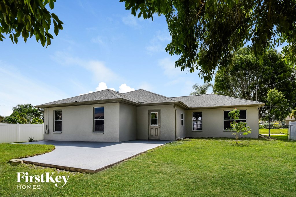A house with a grey roof and a white fence.