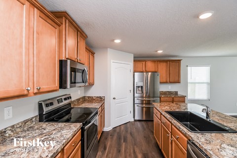 A kitchen with wooden cabinets and granite countertops.