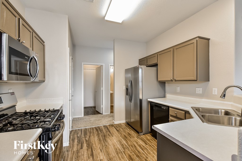 A kitchen with a stove top oven, microwave, and a sink.