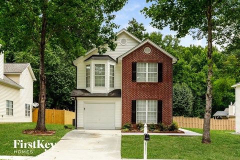 a brick house with a white garage door and a lawn