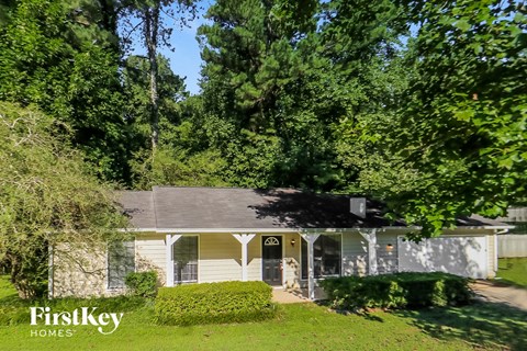 a white house with a yard and trees