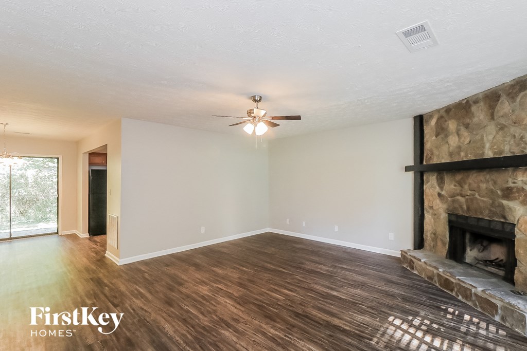 a living room with a fireplace and a ceiling fan