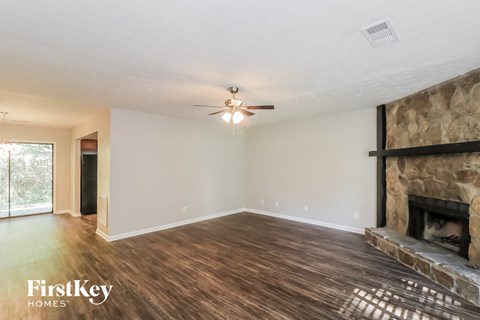 a living room with a fireplace and a ceiling fan