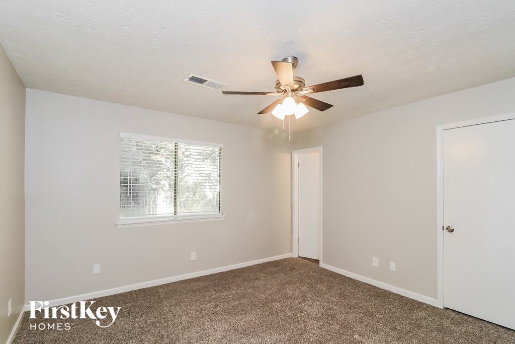 a bedroom with a ceiling fan and a window