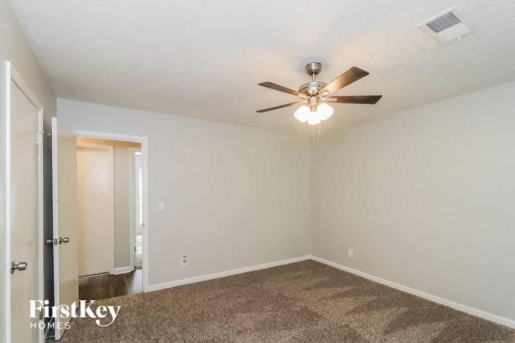 a bedroom with a ceiling fan and a door to a closet
