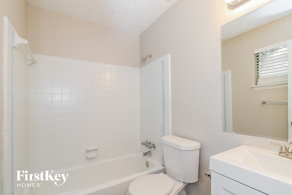 a bathroom with a toilet and a tub and a sink