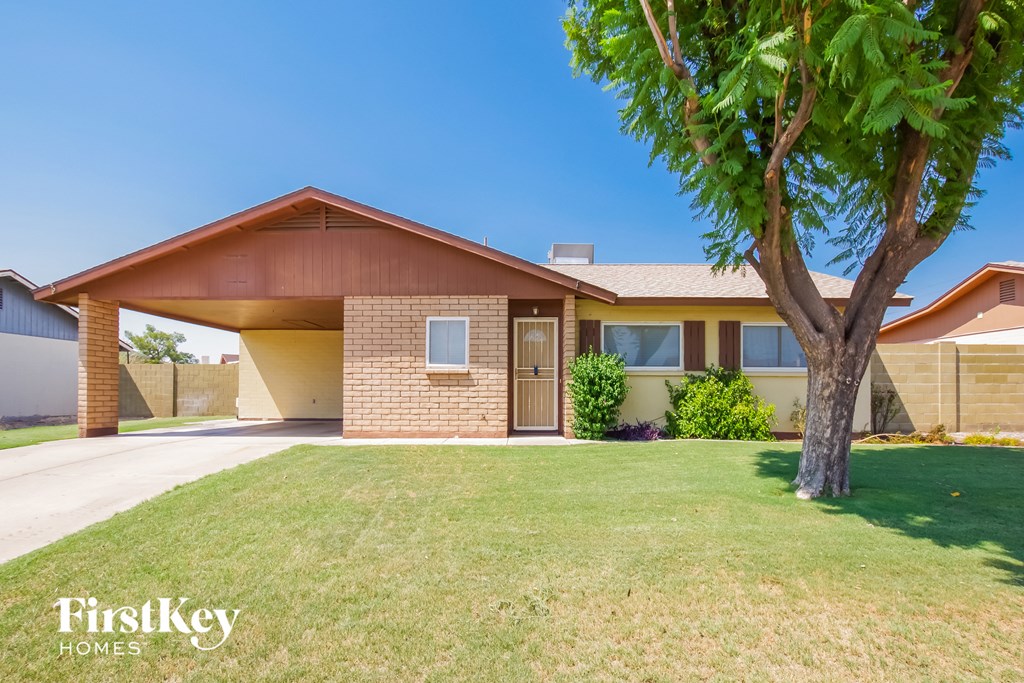 a house with a lawn and a tree in front of it