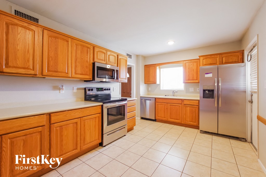 a kitchen with wooden cabinets and stainless steel appliances
